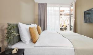 纽伦堡Living Hotel Nürnberg的卧室配有一张带白色床单和枕头的大床。