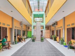 TumbangrunganGriya Tambun Raya RedPartner的学校大楼的走廊,有人坐