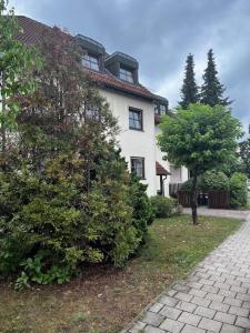纽伦堡的施韦格Cozy&spacious topfloor apartment的前面有一棵树的大白色房子