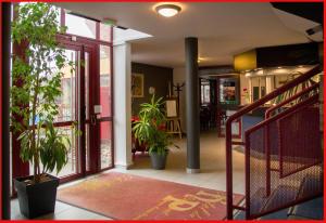 里摩日Hôtel du Parc Limoges & Restaurant "Le temps d'une pause"的建筑中带有盆栽的走廊和楼梯
