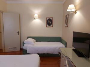 摩德纳PHI Hotel Canalgrande的酒店客房,配有床和电视