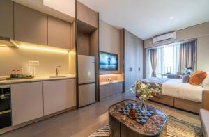 广州米莱尼亚行政公寓（广州火车东站珠江新城店）的一间卧室配有一张床,厨房配有桌子