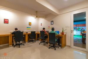 班加罗尔Zostel Bangalore (Koramangala)的两个人坐在办公室的桌子上