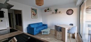 尼斯HOME ET HOLIDAY Le Petit Manseng的客厅配有蓝色椅子和桌子