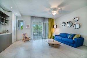 巴亚希贝Tracadero Beach Resort的客厅配有蓝色的沙发和桌子