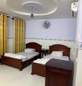 胡志明市Phúc Lộc Thọ Hotel的一间卧室配有两张床和一张桌子