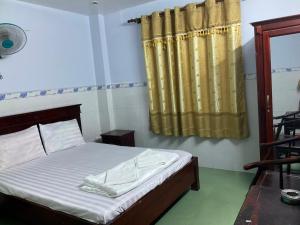 胡志明市Phúc Lộc Thọ Hotel的一间卧室配有床和黄色窗帘