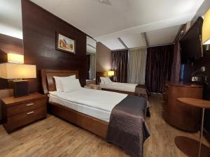 普列文普列文城市酒店的酒店客房设有两张床和一张桌子。