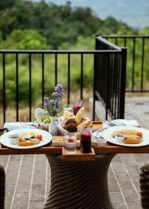 康提Celestial Hills - Villas & Suites by The Clarks的餐桌上放有食物盘子的桌子