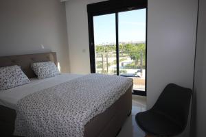 拉奥拉达达COSTA ELISA20 MIL PALMERAS的卧室配有床、椅子和窗户。