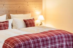 格拉绍Das Achental Resort的卧室内的两张床和一张铺着地毯的毯子