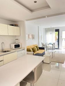 弗拉门卡海滩La zenia Bulevard apartments的厨房和带白色橱柜的客厅