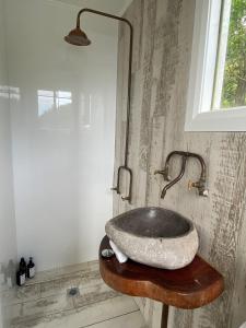 Daleys PointThe Boathouse的木桌上设有石制水槽的浴室