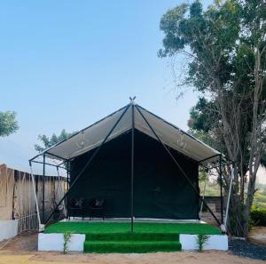 普杰K's Villa Bella的绿色草坪上带两把椅子的黑色帐篷