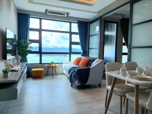 哥打京那巴鲁J'Stay Seaview Suite Jesselton Quay Kota Kinabalu的客厅配有沙发和桌椅