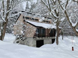 信浓Labo Land Kurohime "rental cottage cottage" - Vacation STAY 62600v的树林里积雪覆盖的房子