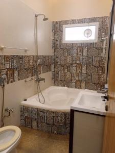 卡拉奇White Lotus Karachi的带浴缸、卫生间和盥洗盆的浴室