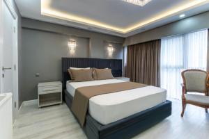 伊斯坦布尔Classio Hotel Kadıköy的一间卧室配有一张大床和一把椅子