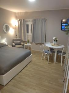 罗马Old Bridge Minisuite的一间卧室配有一张床、一张桌子和一张沙发