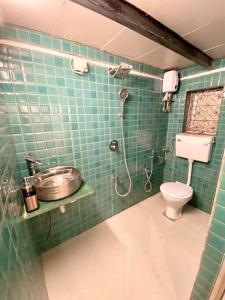 孟买Bandra Cottage (With Yard)的绿色瓷砖浴室设有淋浴和卫生间