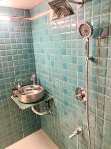 孟买Bandra Cottage (With Yard)的蓝色瓷砖浴室设有水槽和淋浴