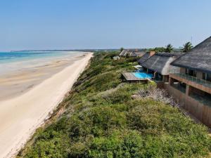维兰库卢什Collection Luxury Accommodation: Quinta Do Sol, Vilanculos, Mozambique的享有海滩和建筑的空中景致