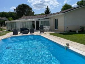 CursanVilla entre bordeaux et saint emilion的一座大型蓝色游泳池,位于房子旁边