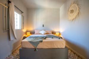 拉拉塔可库斯特Piccolo Bike Hotel的一间卧室配有一张带两盏灯的床。
