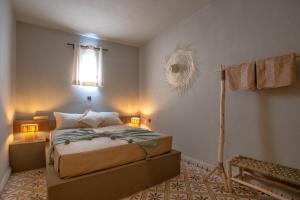 拉拉塔可库斯特Piccolo Bike Hotel的一间卧室配有一张带两盏灯的床和风扇。