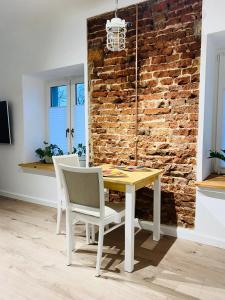 Borzęcin DużyCottage Studio的一间设有桌椅和砖墙的用餐室