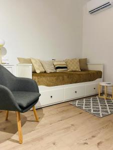 Borzęcin DużyCottage Studio的一张位于配有沙发和椅子的房间的床铺