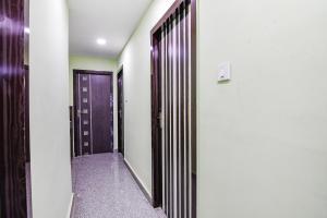kolkataFabExpress Laxmi Inn的一条带紫色门的走廊和一条带