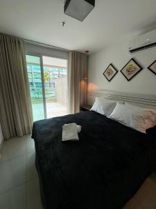 巴西利亚Luxuoso Flat Brisas do Lago Terraço Aconchegante的一间卧室配有一张黑色床,上面有毛巾