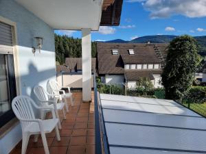策尔阿姆哈尔梅尔斯巴赫Tannenblick的设有一个配有白色椅子的阳台,享有美景。