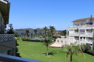 弗洛里亚诺波利斯Completo apartamento em Resort na beira da lagoa的享有大楼和棕榈树庭院的景色