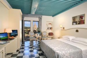 乌尔比诺Hotel Raffaello - Self Check-in Free的一间卧室配有一张床和一张带电脑的书桌