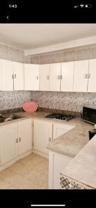 乌姆苏克MB DREAMS DJERBA的厨房配有白色橱柜和柜台上的粉红色碗