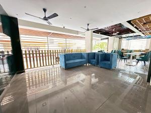 GoaSkon Baga Bliss Hotel by Orion Hotels的大堂设有蓝色的沙发、桌子和窗户。