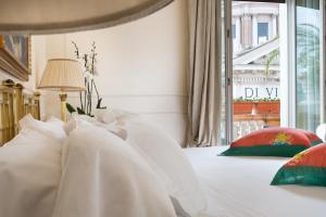 罗马广场大酒店的卧室配有带白色枕头的床和窗户。