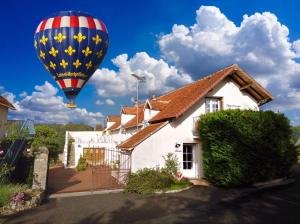 昂热Guest House "Près des Montgolfières"的飞过房子的热气球