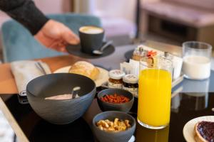 米兰AXYHOTELS InnStyle Milano的餐桌上放着一碗食物和橙汁