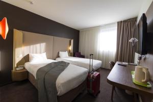 勒芒Campanile Le Mans Centre - Gare的酒店客房带两张床和行李箱
