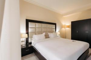 埃里温埃里温巴黎酒店的卧室配有一张白色大床和两盏灯。