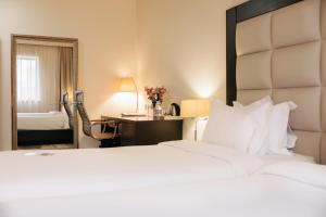 埃里温埃里温巴黎酒店的酒店客房带一张床、一张书桌和一面镜子