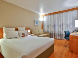 里约热内卢索菲特里约热内卢都蒙特酒店的酒店客房设有一张白色大床和一张书桌