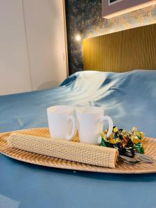 阿罗纳La Dolce Vita Penthouse 2 Bedroom Apartment的床上放两个咖啡杯和一盘食物
