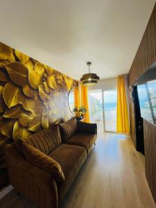 阿罗纳La Dolce Vita Penthouse 2 Bedroom Apartment的一间客厅,在石墙前配有一张棕色沙发