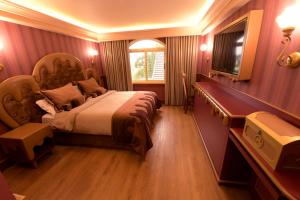 格拉玛多Chocoland Hotel Gramado soft opening的一间卧室设有一张大床和一个窗户。