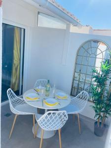 阿罗纳La Dolce Vita Penthouse 2 Bedroom Apartment的窗户客房内的白色桌椅