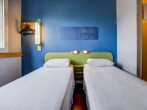 里约热内卢ibis budget Rio de Janeiro Nova America的蓝色墙壁客房的两张床